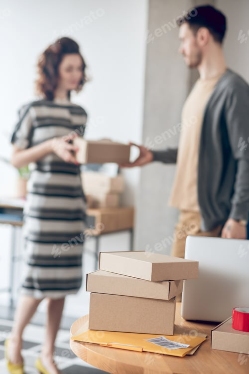 Preview: Online store worker handing over a package to a courier