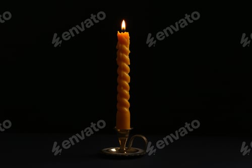 Preview: Burning candle in candlestick on black background