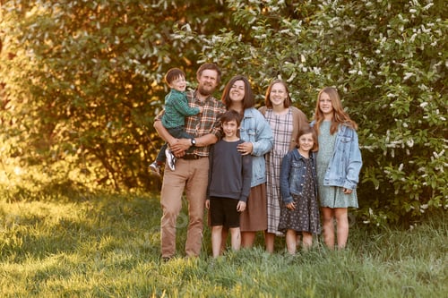 Preview: Large friendly family in the summer on the field.