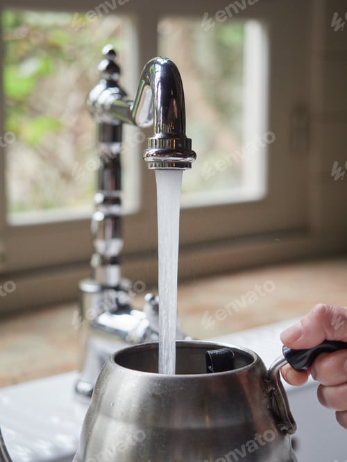 Preview: water flowing out of the kitchen faucet to fill stainless steel pot