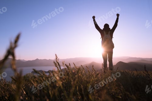 Preview: Young standing man with backpack. over sunset in nature