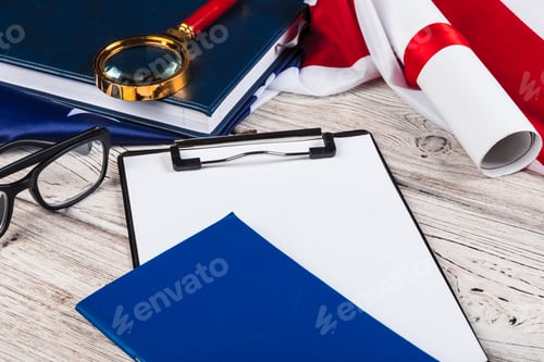 Preview: blank clip board and USA flag on wooden background