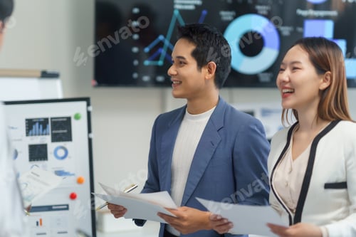 Preview: Asian businesspeople discussing financial charts and graphs during a meeting