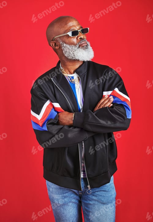 Preview: Studio shot of a senior man wearing retro attire while posing against a red background