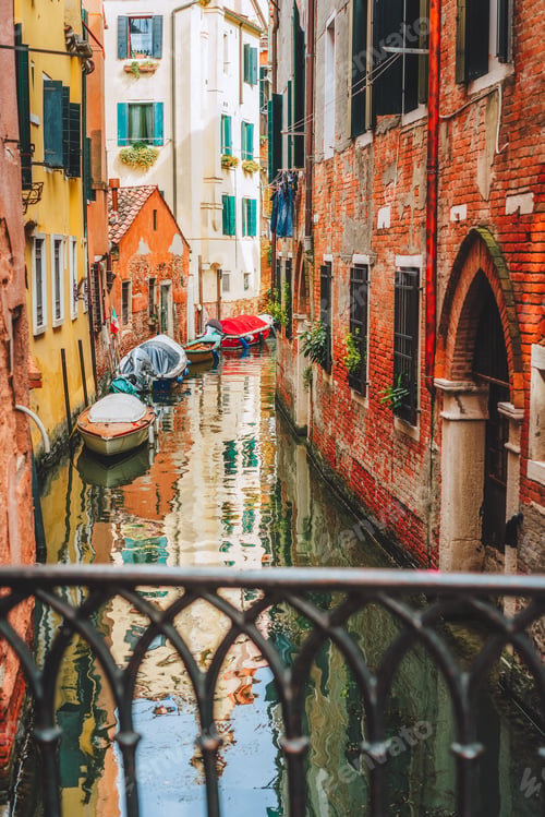 Preview: Venice, Italy. Narrow channel street and colored houses with local boats in Venezia