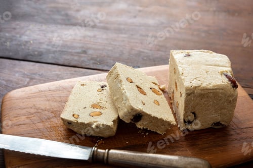 Preview: Halva almond nuts slices on wooden table background