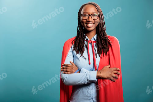 Preview: Joyful smiling heartily brave and selfless justice defender standing with arms crossed on blue