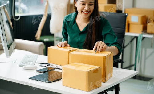 Preview: Business owner woman prepare parcel box and standing check online orders for deliver