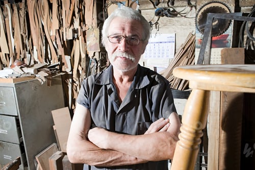 Preview: Experienced craftsman proudly standing in his workshop