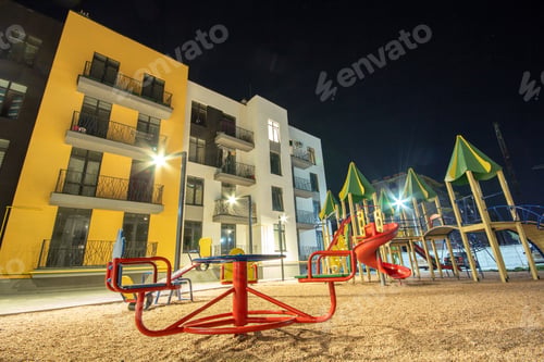 Preview: Children playground at night in residential district yard between apartment buildings.