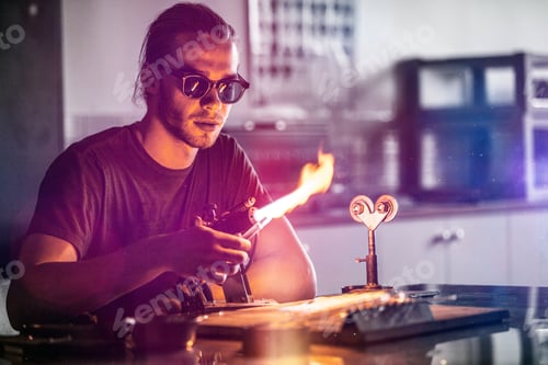 Preview: Glassblowing Young Man Working on a Torch Flame with Glass Tubes