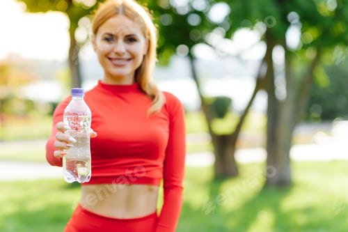 Preview: Slim young woman drinking water after training