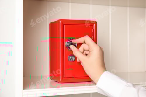 Preview: Woman opening red steel safe with mechanical combination lock, closeup