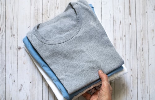 Preview: Folded t-shirts in blue, gray, and white