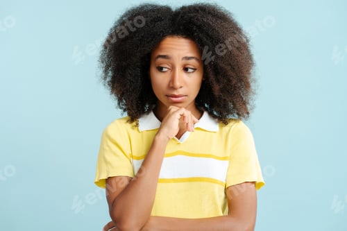 Preview: Excited beautiful African American woman with curly hair looking away isolated on blue background