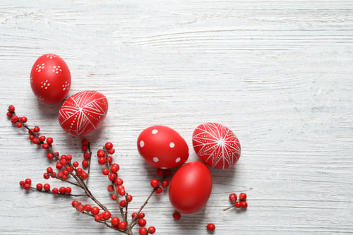 Preview: Flat lay composition with painted Easter eggs on wooden table, space for text