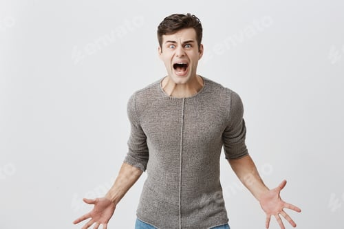 Preview: Annoyed caucasian man holds hands in furious gesture, screams loudly as has quarrel with wife, sorts