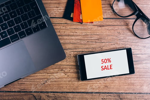 Preview: Smartphone on wooden table. Black friday advert. Top view