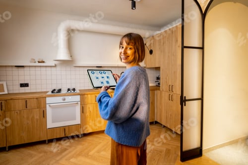 Vista previa: Woman controls kitchen appliances with a digital tablet