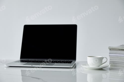 Preview: laptop with blank screen, stack of journals and coffee cup isolated on grey