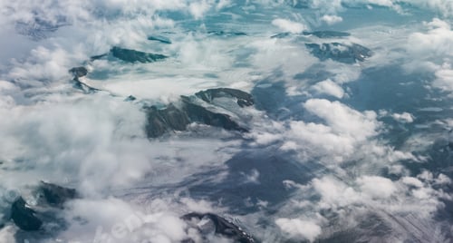 Preview: Aerial view of majestic mountains and glaciers shrouded in clouds over Svalbards landscape