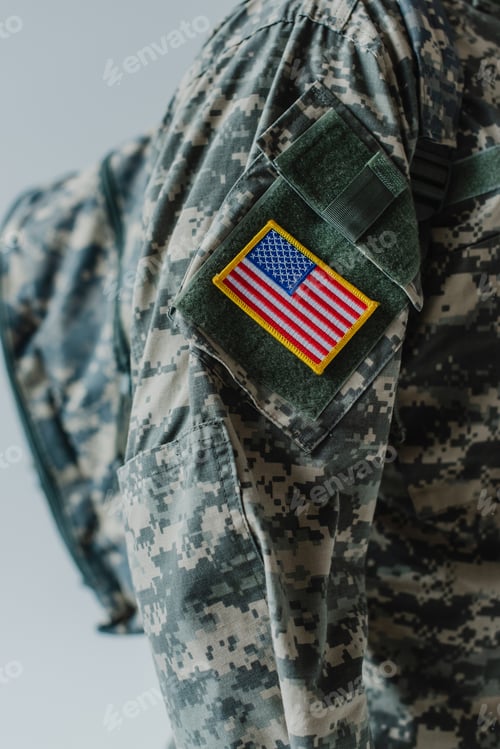 Preview: cropped view of American soldier in army uniform standing with backpack isolated on grey