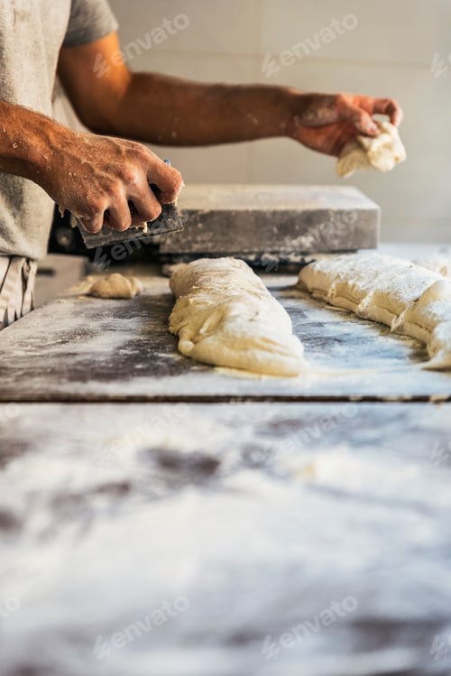 Preview: Baker preparing bread. Close up of hands kneading dough.