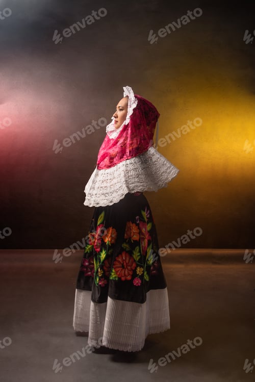 Preview: A woman in a colorful dress stands in front of a wall