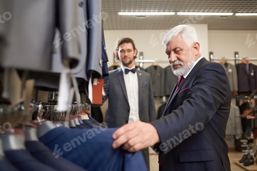 Preview: Two attractive men buying fashion costumes in male store