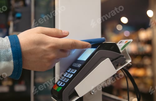 Preview: Close up of male hand holding smartphone in payment terminal.