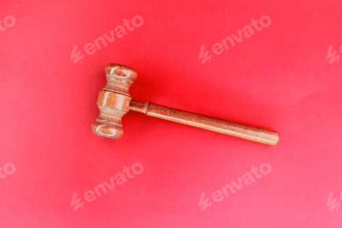 Preview: Judge's gavel on red background.