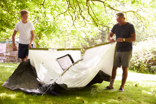 Preview: Father And Teenage Son Putting Up Tent On Camping Trip