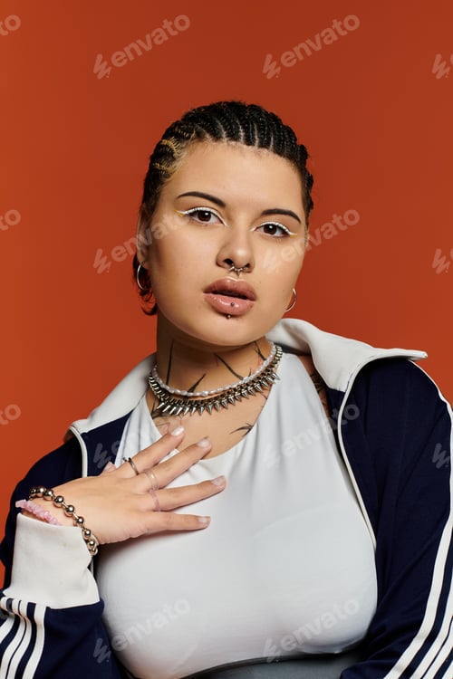 Preview: Young stylish woman poses confidently against a vibrant orange backdrop showcasing modern fashion