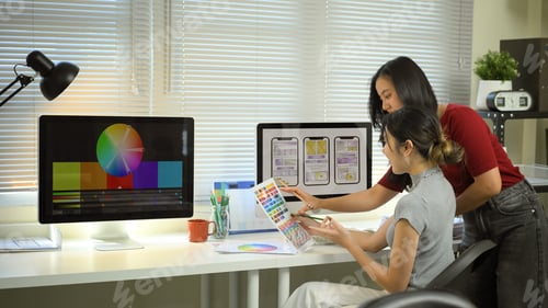 Preview: Two designers collaborate on mobile app UX UI, reviewing color palettes and wireframes