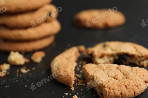 Preview: Delicious cookie with raisins on black table, closeup