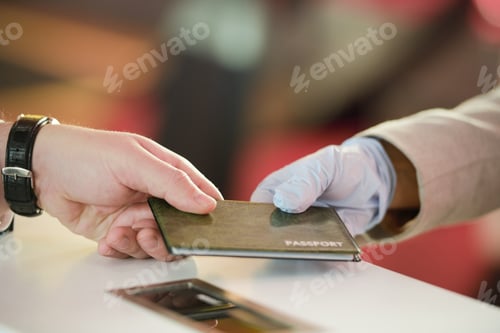 Preview: Hand of mature man taking back his passport after registration before flight at the check desk