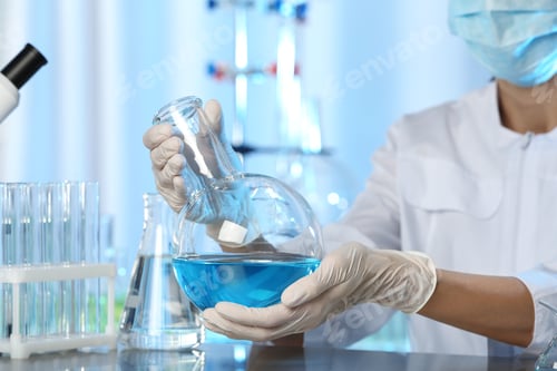 Preview: Doctor holding Florence flask with blue liquid, closeup. Laboratory analysis