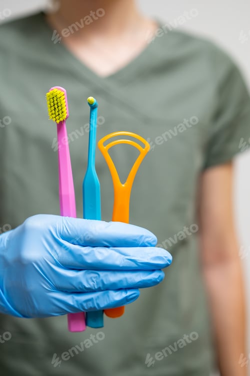 Preview: Differenet toothbrushes in dentists hand in rubber gloves.