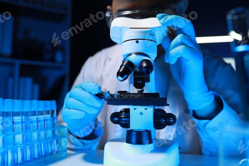 Preview: A talented scientist sits in his lab while using a microscope to look for microscopic organisms in a