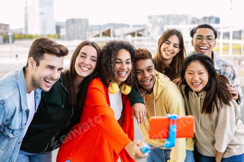 Preview: Happy young group of multiracial friends taking self portrait with selfie stick