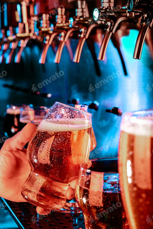 Vista previa: Mano de camarero sirviendo una cerveza lager grande en el grifo