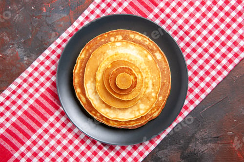 Preview: Top view of homemade pancakes on a red stripped towel