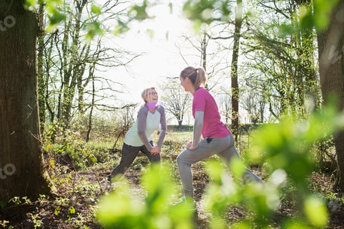 Preview: Women face to face in forest hands on knee lunging