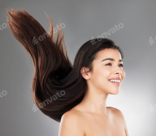 Preview: Studio shot of a beautiful young woman with flowing hair against a grey background
