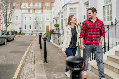 Preview: Young couple strolling and holding hands on Kings Road, London, UK