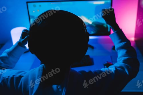 Preview: Asian girl playing shooter online video game - Technology trend concept - Focus on headphones