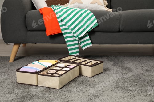 Preview: Organizers with folded clothes on gray rug indoors