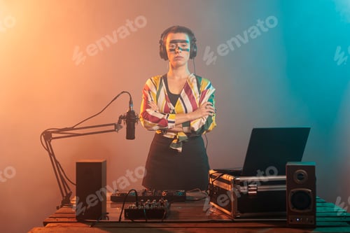 Preview: Female performer posing with arms crossed at turntables