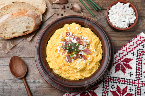 Preview: Traditional Ukrainian banosh served with brynza and pork cracklings on wooden table, flat lay