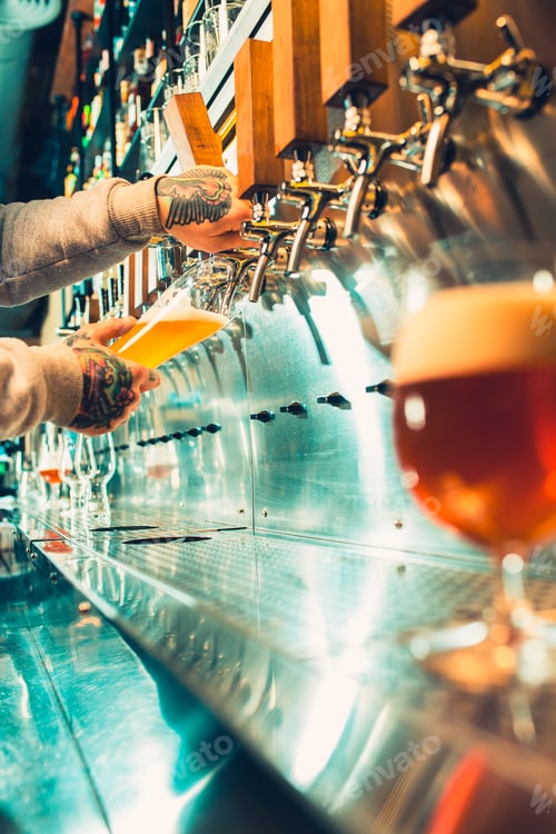 Preview: Hand of bartender pouring a large lager beer in tap.